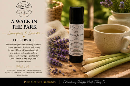 A lip balm bottle labeled 'A Walk in the Park' by A Blind Date, styled on a wooden surface with lemongrass, lavender flowers, and a ceramic mug. The left side features a text panel describing the product as a lip service with lemongrass and lavender.
