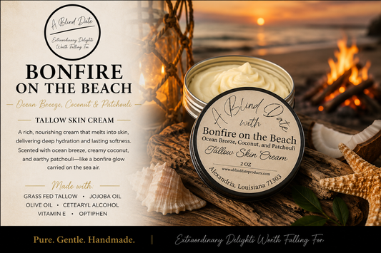 Luxury Bonfire on the Beach Tallow Skin Cream by A Blind Date displayed on driftwood beside seashells at a sunset beach bonfire. Handmade tallow skin cream scented with ocean breeze, coconut, and patchouli, creating a warm coastal atmosphere while deeply moisturizing and nourishing the skin.